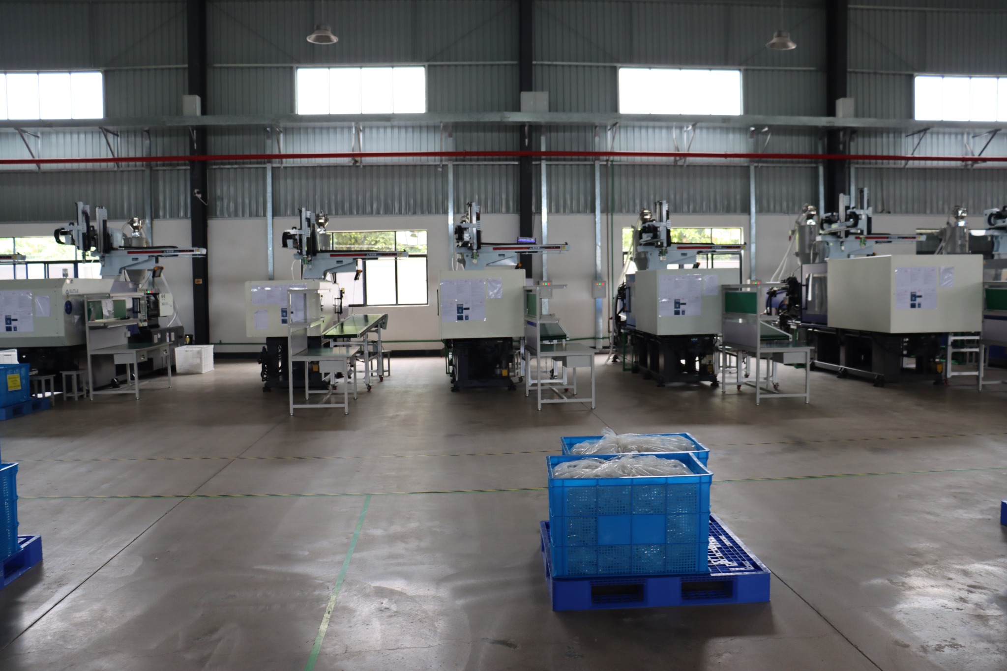 Injection molding workstations and material bins in the workshop